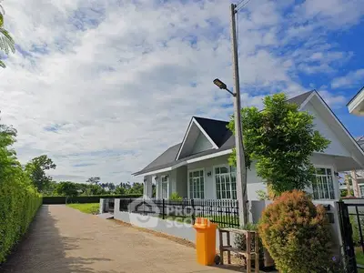 Charming suburban house with lush greenery and spacious driveway under a clear blue sky.