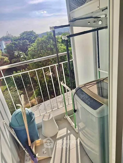 Charming balcony with washing machine and lush green view, perfect for urban living.