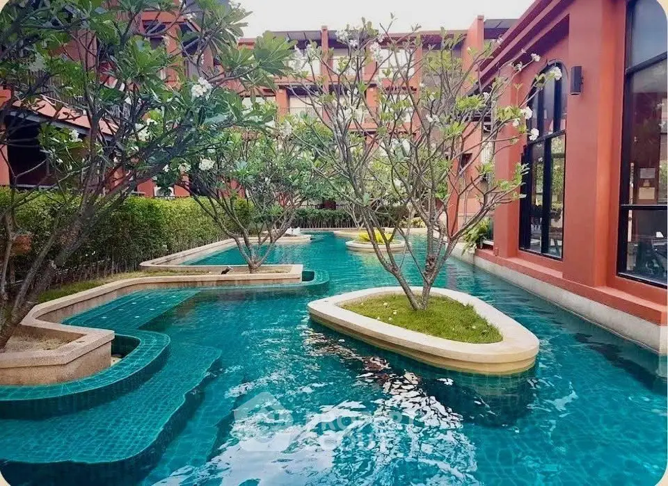 Luxurious resort-style pool with lush greenery and modern architecture, perfect for relaxation and leisure.