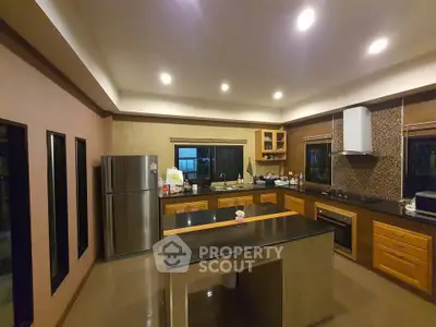 Spacious modern kitchen with sleek countertops and stainless steel appliances.