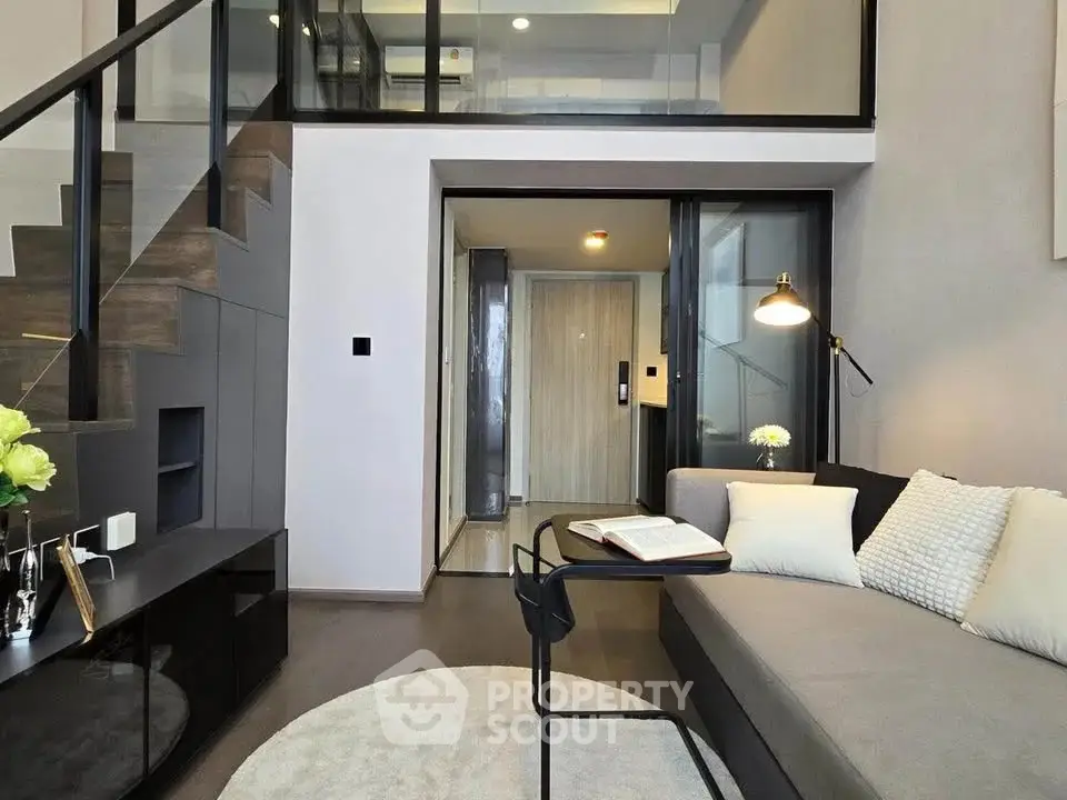 Modern living room with mezzanine, sleek staircase, and cozy seating area