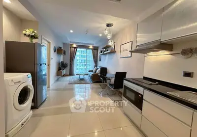 Modern open-plan kitchen and living room with sleek appliances and stylish decor in a high-rise apartment.
