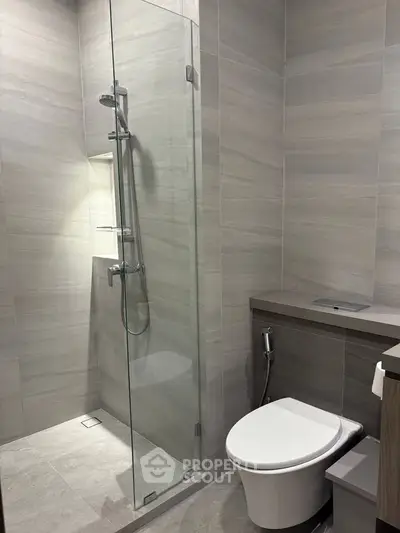 Modern bathroom with sleek shower and toilet in contemporary design.
