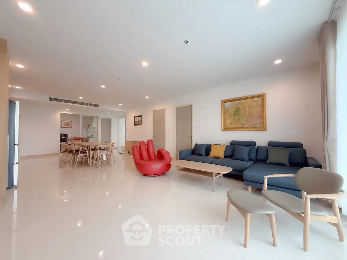 Spacious modern living room with stylish furniture and open dining area.