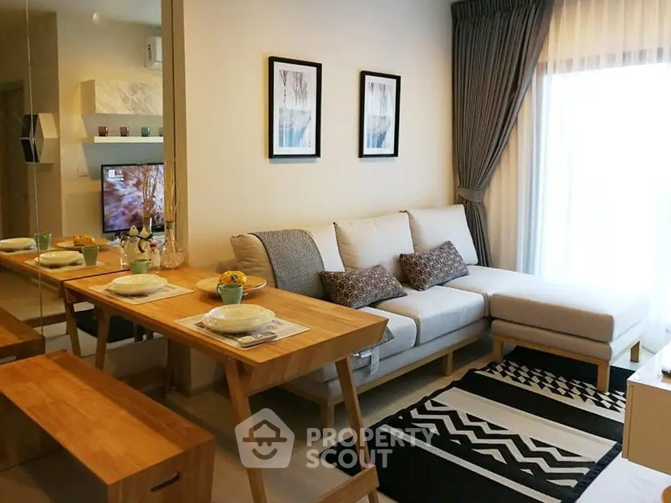 Modern living room with stylish decor and natural light, featuring a cozy sofa and dining area.