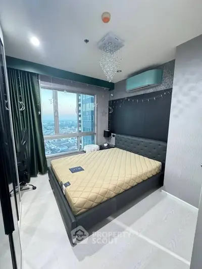 Modern bedroom with large window offering stunning city views, featuring stylish decor and ample natural light.