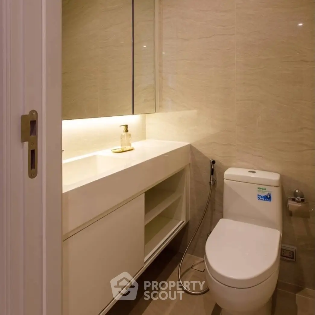 Modern bathroom with sleek design and ambient lighting, featuring a spacious vanity and contemporary fixtures.