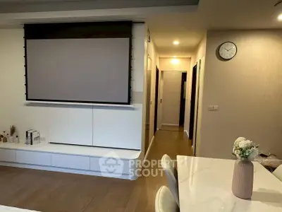 Modern living room with projector screen and elegant dining area