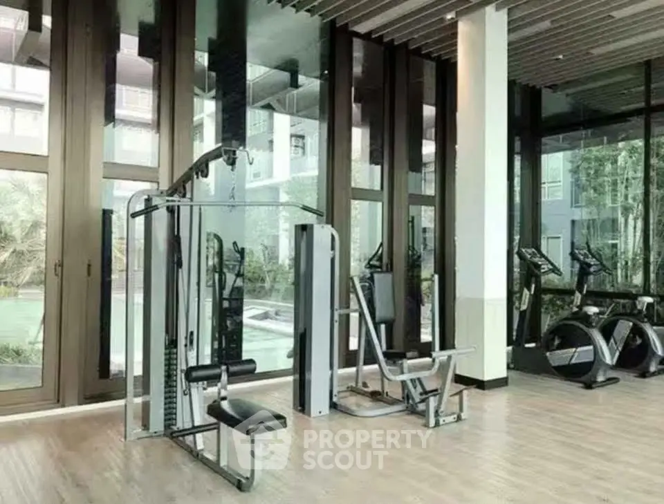 Modern gym with state-of-the-art equipment and large windows offering garden views.