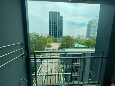 Stunning cityscape view from a modern balcony with lush greenery and high-rise buildings.