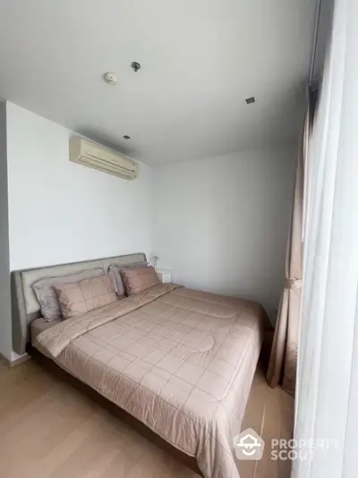 Cozy bedroom with large window and modern air conditioning unit, perfect for relaxation and comfort.