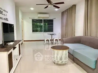 Spacious modern living room with stylish furniture and large window view.