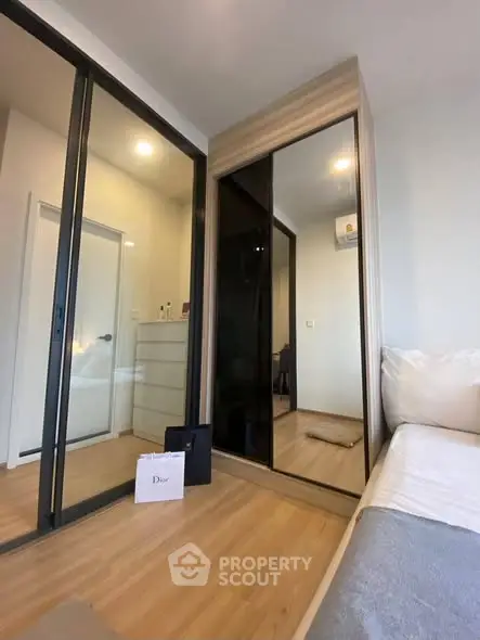 Modern bedroom with mirrored wardrobe and wooden flooring