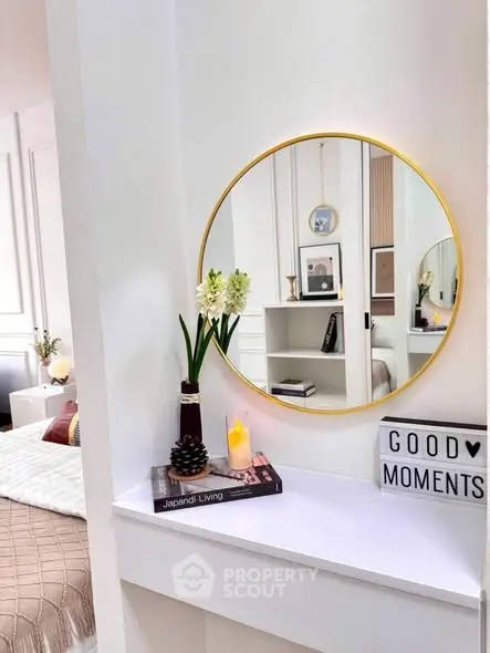 Chic bedroom with stylish decor and round mirror reflecting elegant design.