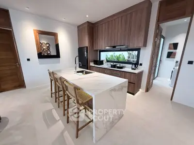 Modern kitchen with marble island and wooden cabinetry in a stylish home