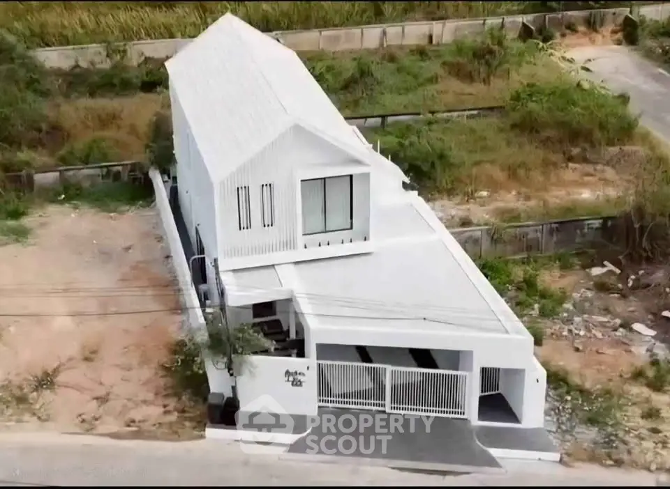 Modern minimalist white house with unique angular design and spacious driveway