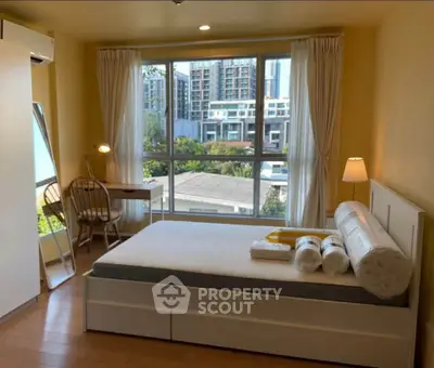 Bright bedroom with large window and modern furnishings in urban apartment