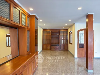 Spacious living room with elegant wooden cabinetry and polished flooring.