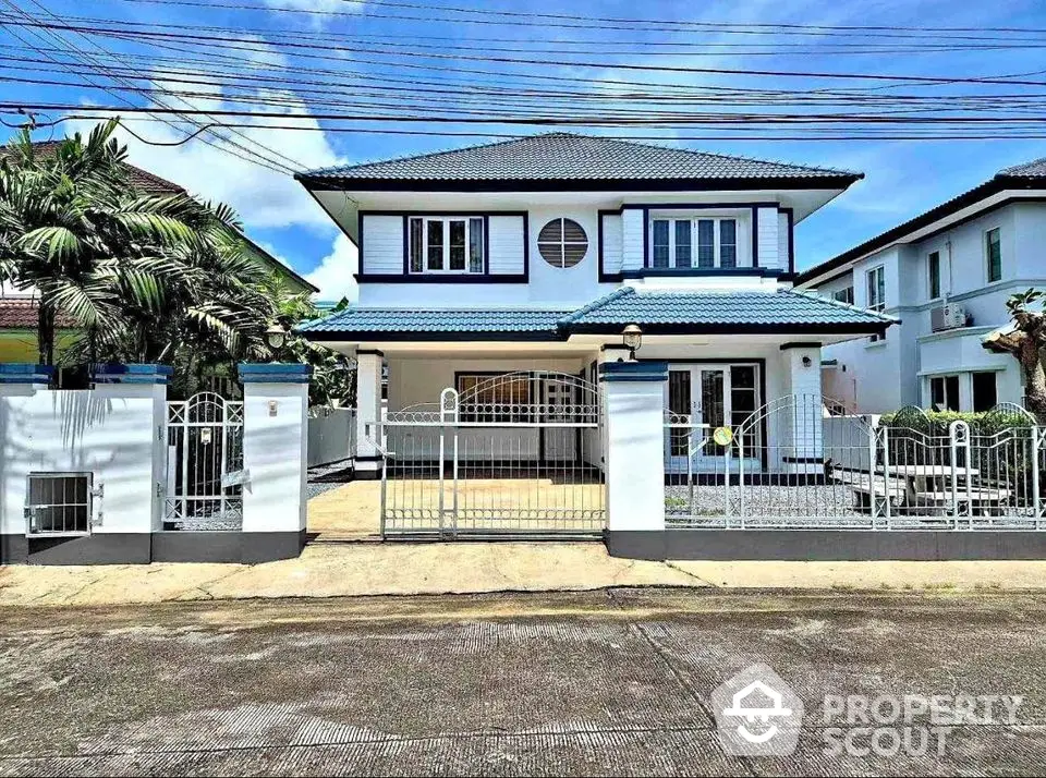 Charming two-story house with gated entrance and spacious driveway in a serene neighborhood.