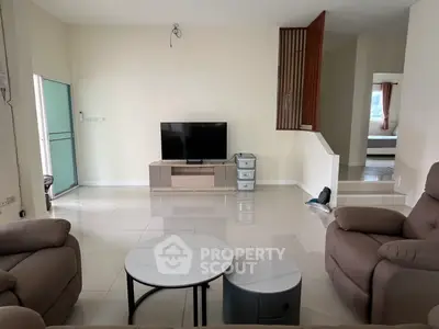 Spacious living room with modern furniture and TV setup, ideal for family gatherings.