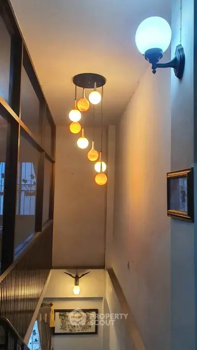 Elegant hallway with modern pendant lighting and decorative wall art