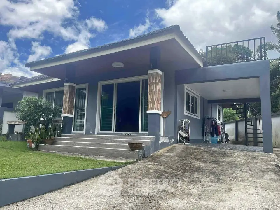 Charming single-story home with modern design, lush garden, and spacious driveway under a clear blue sky.