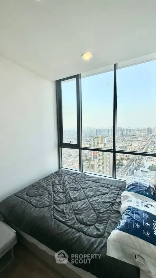 Stunning bedroom with panoramic city view from high-rise window, featuring modern decor and cozy ambiance.