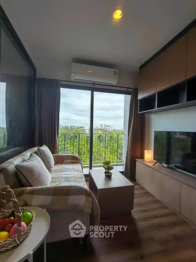 Cozy living room with large window and scenic view, featuring modern furniture and air conditioning.