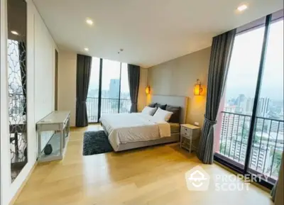 Spacious bedroom with modern design, floor-to-ceiling windows, and a private balcony offering panoramic city views, creating a serene urban retreat.