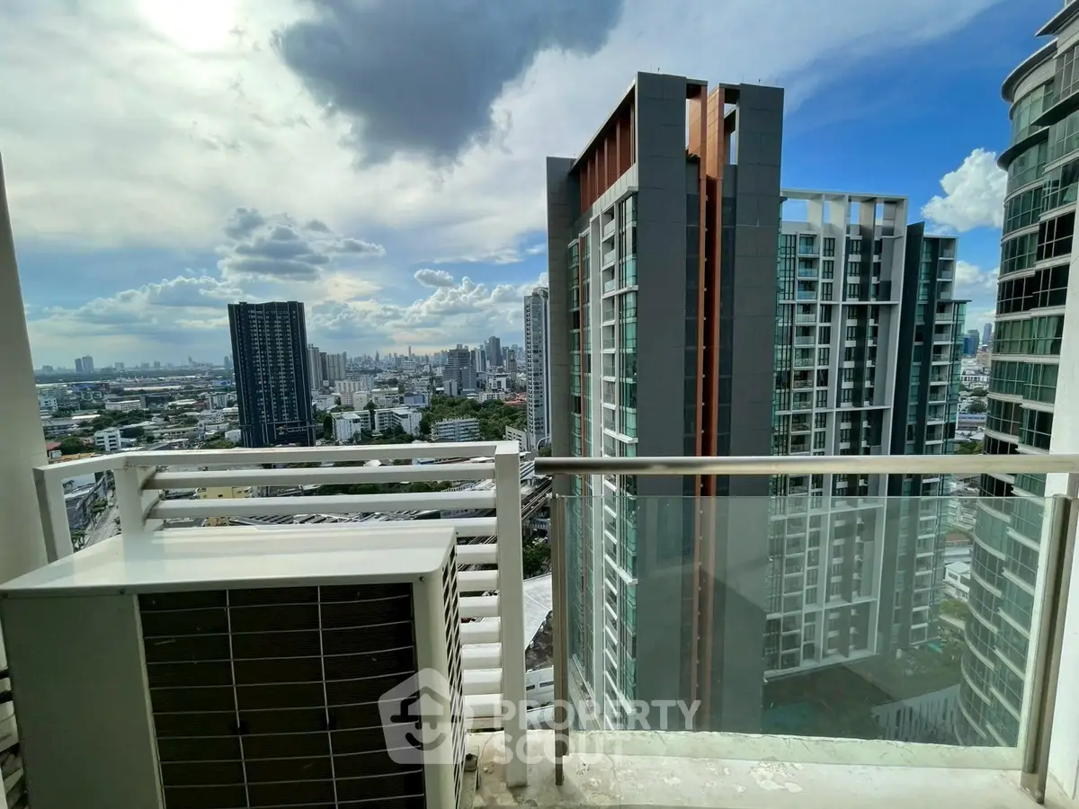 Stunning cityscape view from a modern high-rise balcony with glass railing.