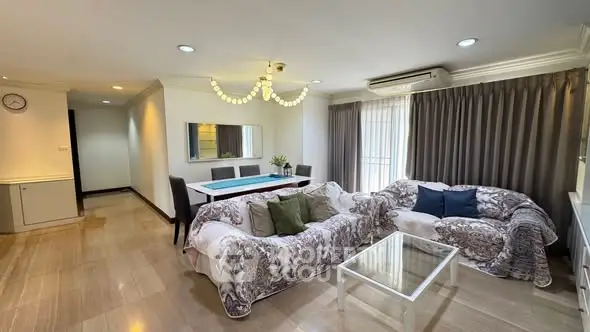 Spacious living room with elegant decor and ample natural light, featuring cozy sofas and a stylish dining area.