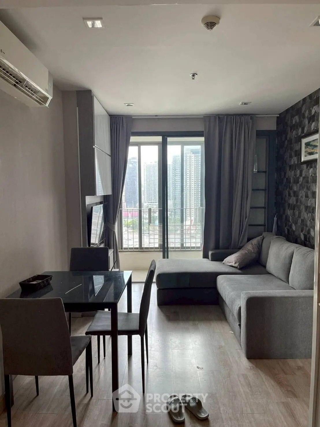 Modern living room with city view, featuring sleek furniture and large windows for natural light.