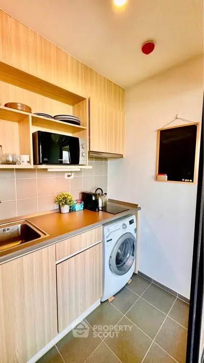 Modern compact kitchen with wooden cabinets and washing machine