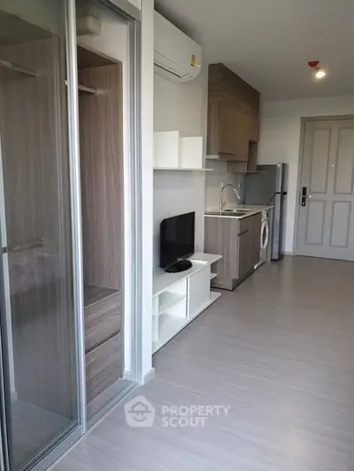 Modern apartment interior with compact kitchen and living area, featuring sleek design and efficient use of space.