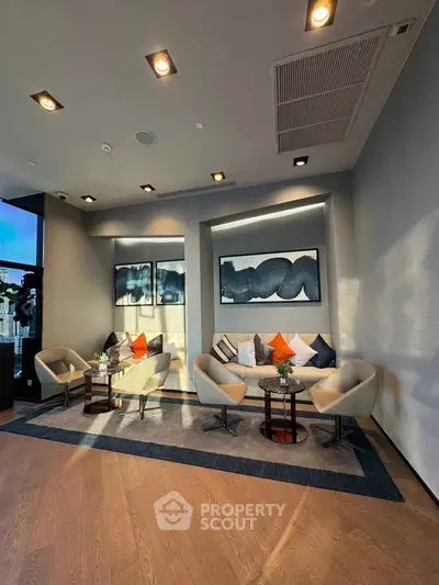 Modern living room with stylish seating and abstract art, perfect for relaxation and entertaining.