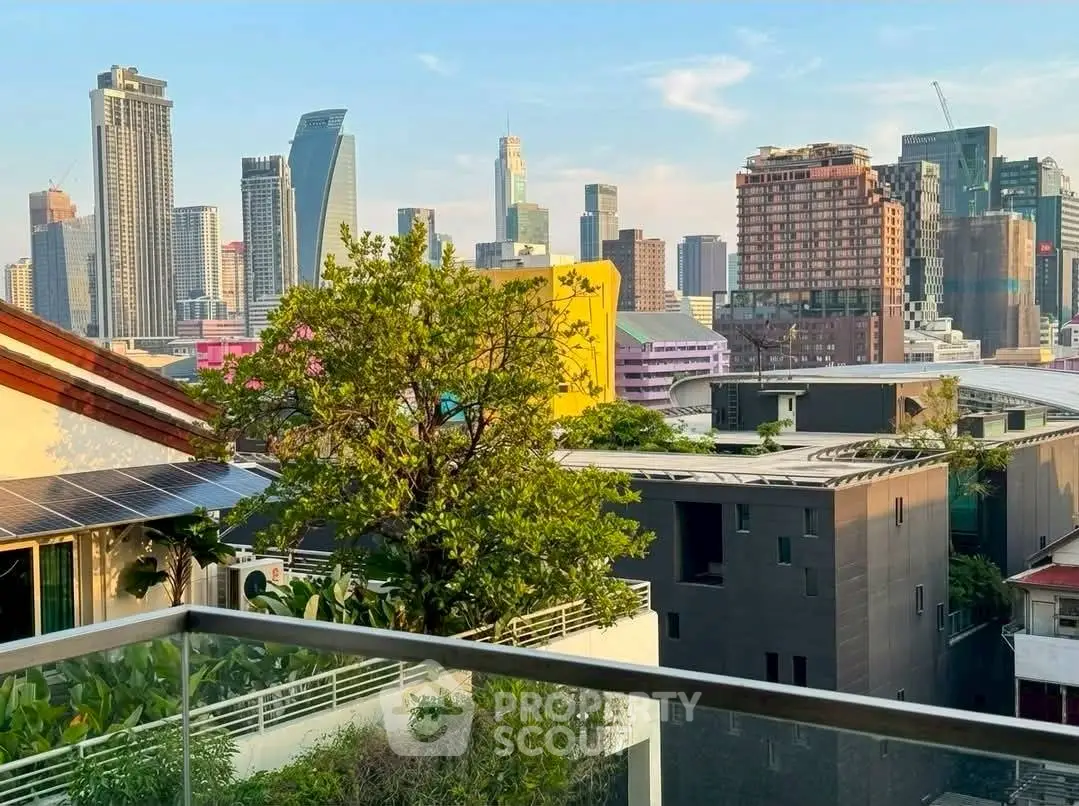 Stunning cityscape view from a modern balcony with lush greenery and urban skyline.