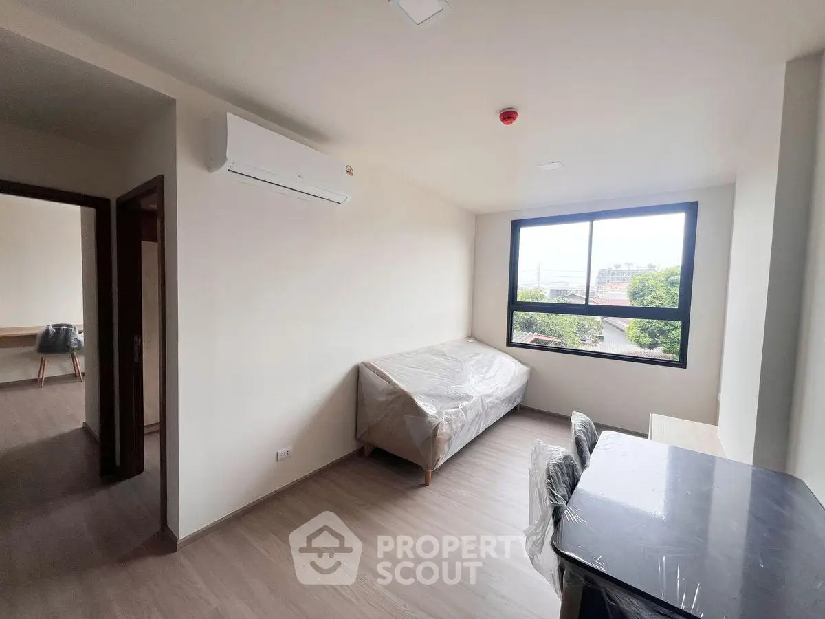 Modern living room with large window and air conditioning in a bright apartment.