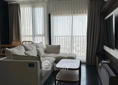 Modern living room with large windows and cozy seating area