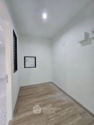 Minimalist interior space with wooden flooring and bright lighting