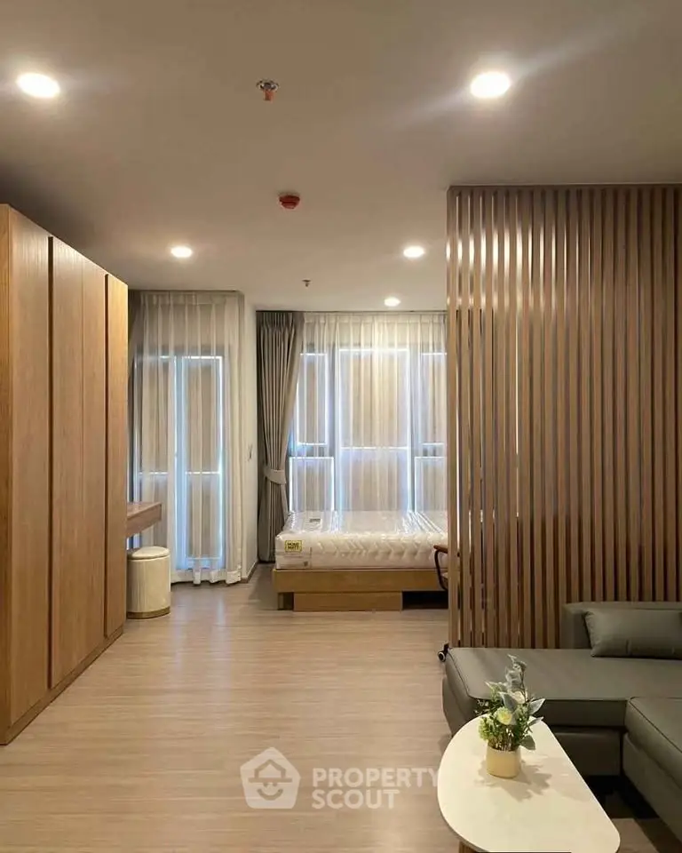 Modern studio apartment with stylish wooden partition and cozy furnishings