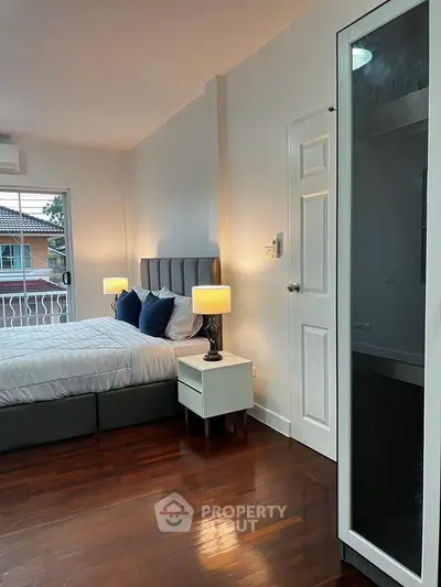 Spacious bedroom with modern decor and balcony view in elegant home