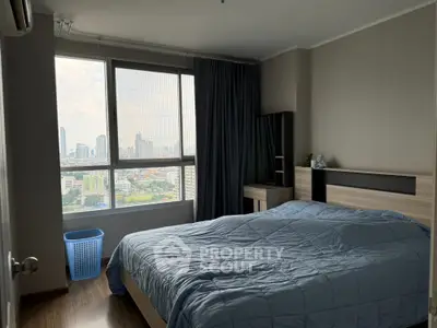 Modern bedroom with city view, featuring a cozy bed and stylish decor.