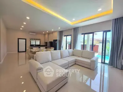 Spacious modern living room with large sectional sofa and pool view, perfect for luxury living.