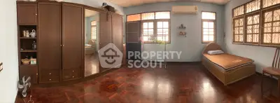 Spacious bedroom with wooden flooring and ample natural light