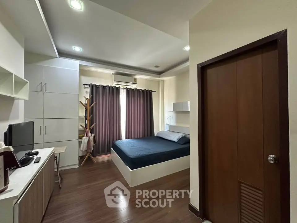 Modern bedroom with sleek design, featuring a cozy bed, built-in storage, and stylish decor.