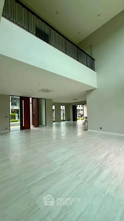 Spacious modern living room with high ceilings and large windows, perfect for natural light and open living.