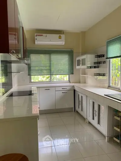 Modern kitchen with sleek cabinetry and large windows for natural light
