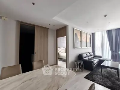 Modern living room with elegant decor and open layout, featuring a cozy seating area and stylish dining table.