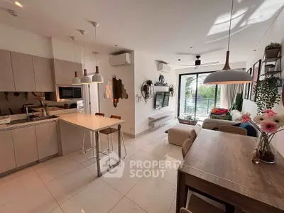 Modern open-plan living room and kitchen with stylish decor and natural light.