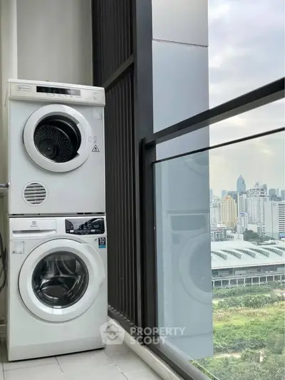 Modern high-rise balcony with washer dryer and stunning city view.